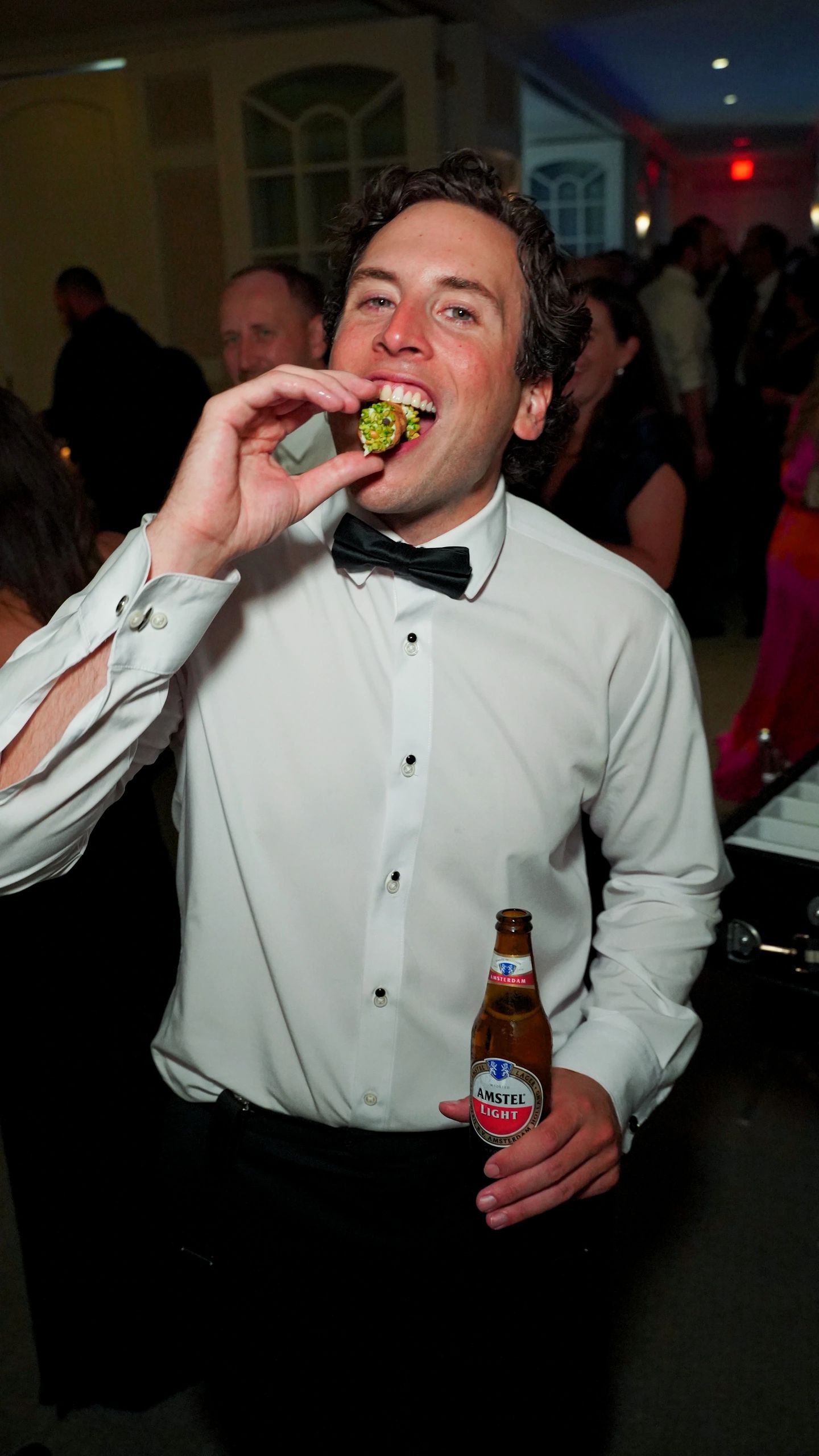 Man in bow tie enjoying appetizer at festive party